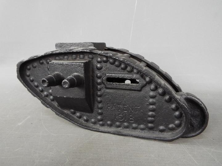 A cast iron money bank in the form of a tank, modelled as a Mark IV Male Tank, marked 'Patent 1918',