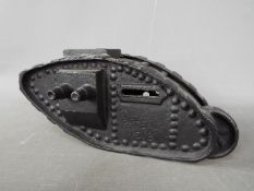 A cast iron money bank in the form of a tank, modelled as a Mark IV Male Tank, marked 'Patent 1918',