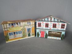 Two vintage charity collection boxes for the National Childrens Home, both in the form of houses,