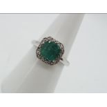 9ct Gold - a 9ct white gold ring set with diamonds and emerald, brilliant shape,size N, weight 0.