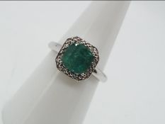 9ct Gold - a 9ct white gold ring set with diamonds and emerald, brilliant shape,size N, weight 0.