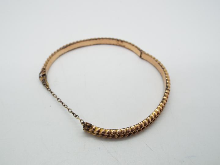 A 9ct gold hinged bangle with safety chain, approximately 6 grams all in. - Image 2 of 3