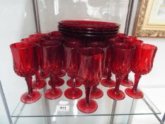 A collection of ruby glassware, wine glasses and plates.