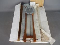 Unused Retail Stock - Two modern wood/glass pendulum clocks height approximately 52 cm in original