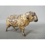 A cold painted, cast iron money bank in the form of a sheep,