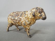 A cold painted, cast iron money bank in the form of a sheep,