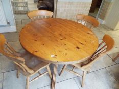A circular top pine kitchen table and four chairs,