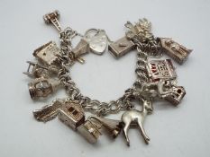 A charm bracelet with a quantity of charms variously stamped 'Silver', 'Sterling', '925'.