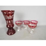 A ruby etched to clear glass vase, approximately 26 cm (h) and four cranberry cut to clear glasses.