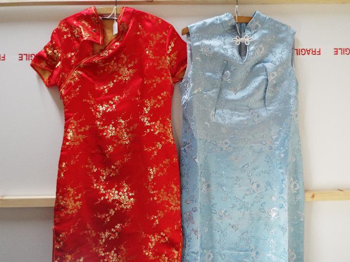 Two Chinese cheongsam type dresses, one in light blue with silver coloured thread,