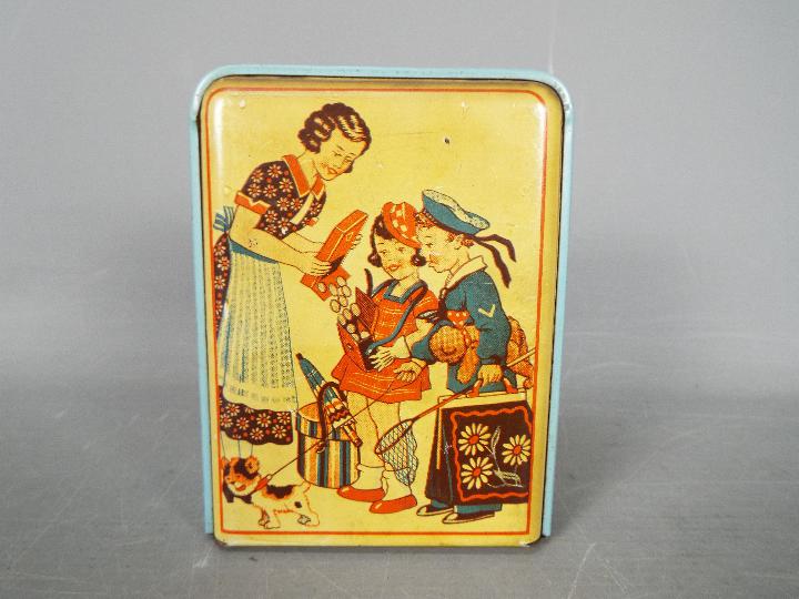 A vintage German, tinplate novelty money bank, one side printed with two children and their mother,