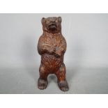 A cold painted, cast iron, money bank in the form of a standing bear,