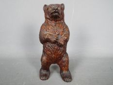 A cold painted, cast iron, money bank in the form of a standing bear,