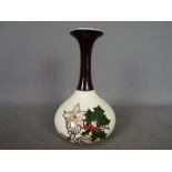 A Lorna Bailey, limited edition bottle vase decorated with holly and mistletoe,