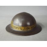 A World War One period novelty, tin money bank in the form of a helmet, titled 'Tommy's Tin Hat' 4.