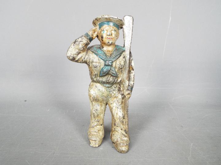 A cold painted, cast iron, novelty money bank in the form of a saluting sailor,