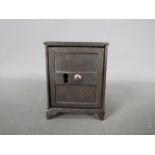 A small, novelty, cast iron money bank in the form of a bank safe, approximately 7 cm (h).