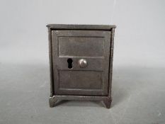 A small, novelty, cast iron money bank in the form of a bank safe, approximately 7 cm (h).