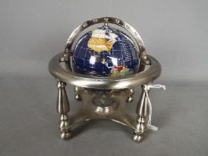 A gemstone terrestrial globe on silvered stand, approximately 18 cm (h).