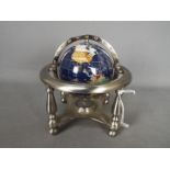 A gemstone terrestrial globe on silvered stand, approximately 18 cm (h).