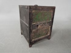 A late 19th century novelty money bank in the form of a bank safe, approximately 9 cm (h).