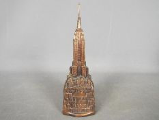 A vintage cast metal money bank of architectural form depicting the Empire State Building,