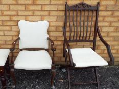 A folding chair and an armchair with white upholstery.