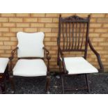 A folding chair and an armchair with white upholstery.