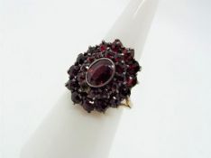 A silver gilt and garnet cluster ring, 900 fineness, size O.