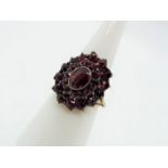 A silver gilt and garnet cluster ring, 900 fineness, size O.