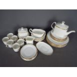 Royal Doulton - A collection of Royal Doulton dinner and tea wares in the Gold Concord pattern,