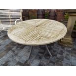 A circular slatted wooden topped garden table by Hartman,