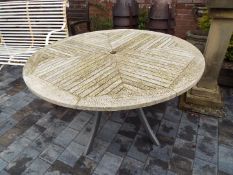 A circular slatted wooden topped garden table by Hartman,
