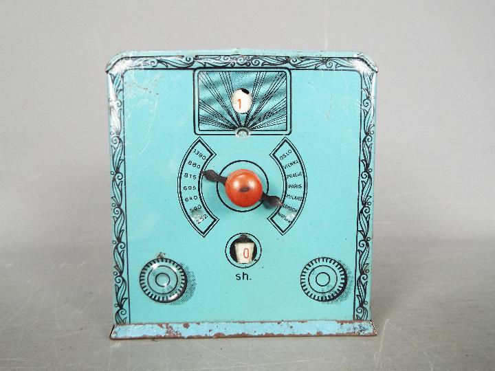 A vintage German tinplate money bank in the form of a valve radio, approximately 10.