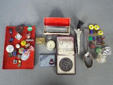 A mixed lot to include a hallmarked silver spoon (approximately 50 grams), pin badges,