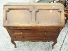 A writing bureau with fall front above two drawers and having fitted interior,