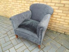 An upholstered armchair on castors.