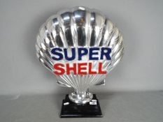 A chrome Super Shell sign on wooden base
