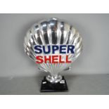 A chrome Super Shell sign on wooden base