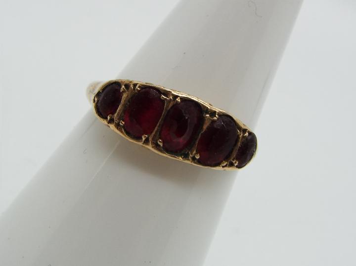 A 9ct gold and garnet ring, size O + ½, approximately 1.9 grams all in. - Image 2 of 6