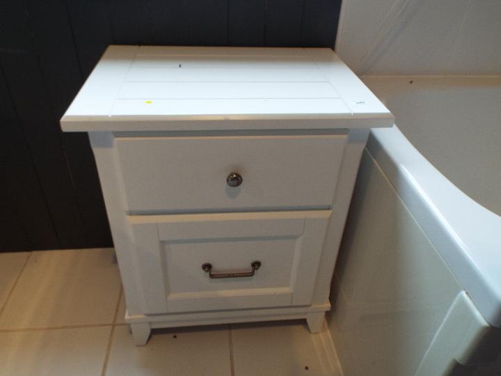 A white bathroom cabinet measuring approximately 64 cm x 54 cm x 38 cm.