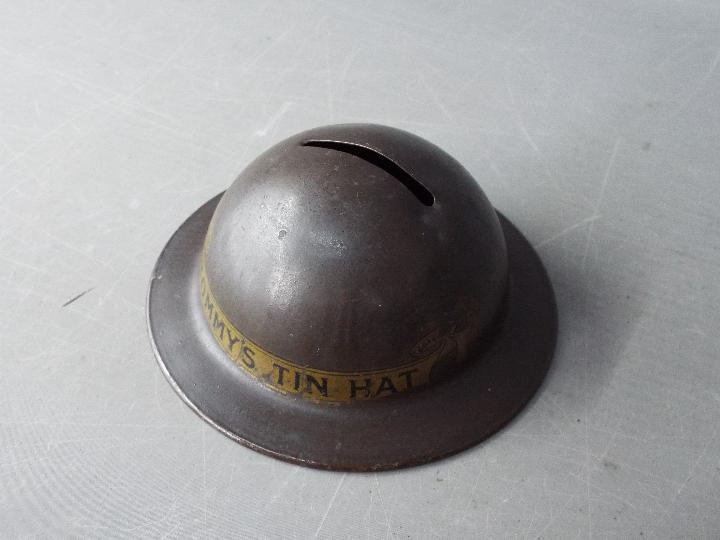 A World War One period novelty, tin money bank in the form of a helmet, titled 'Tommy's Tin Hat' 4. - Image 2 of 6