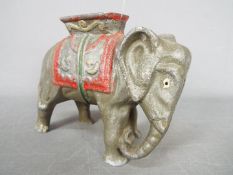 A vintage cast aluminium, novelty money bank in the form of an elephant with howdah,