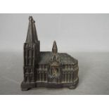 A vintage, cast metal, money bank of small scale depicting Cologne Cathedral, approximately 9.