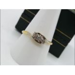 An 18ct gold and platinum crossover ring set with three old cut diamonds approx 20pts,