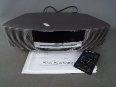 A Bose Wave Music System III with power cable, instructions and remote.
