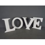 Four large ceramic letters to spell out 'LOVE'.