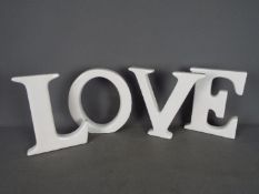 Four large ceramic letters to spell out 'LOVE'.