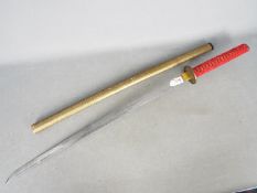 A replica Katana with red cord-wrapped handle and yellow metal scabbard Blade length approx. 69 cm.