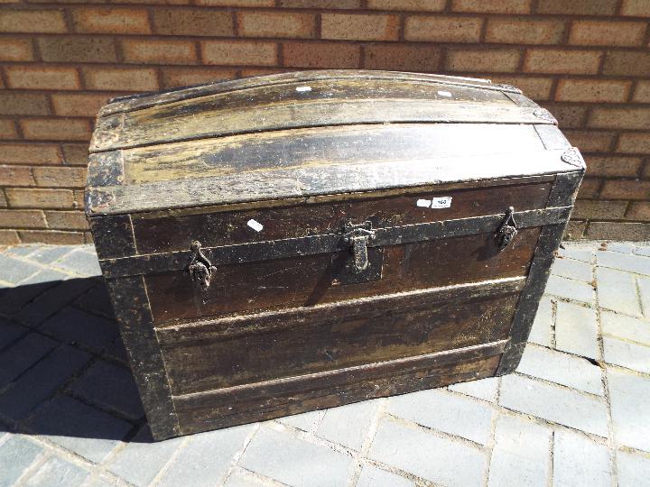 A metal bound dome top trunk, approximately 64 cm x 81 cm x 49 cm.